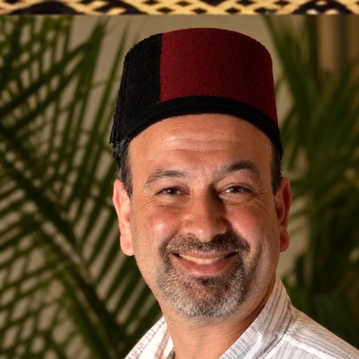 Chef Karim smiling and wearing a traditional Moroccan fez