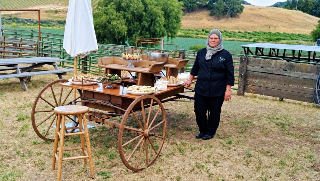 Catering team member beside a rustic appetizer cart