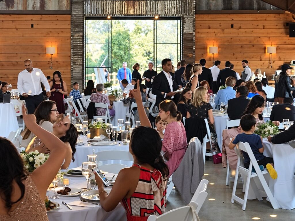 Wedding guests gathered at tables inside a reception venue